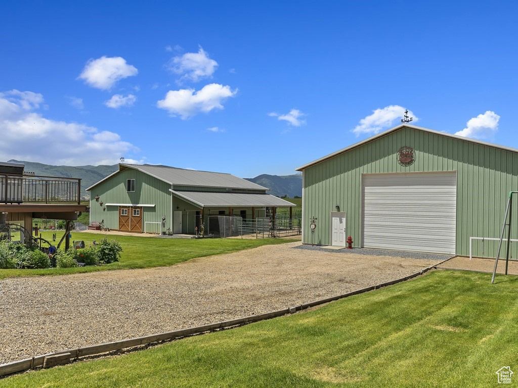 View of front of home featuring an outdoor structure, a garage, and a front yard