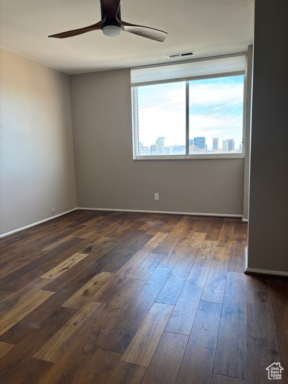 Spare room featuring dark hardwood / wood-style floors and ceiling fan