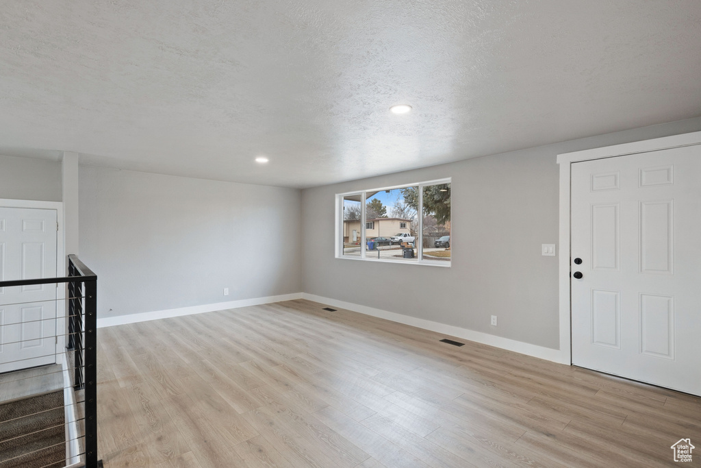 Spare room featuring light hardwood / wood-style flooring and a textured ceiling