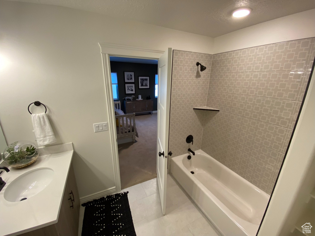 Bathroom featuring vanity, tiled shower / bath combo, and tile floors