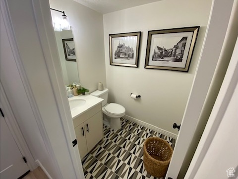 Bathroom with toilet, tile flooring, and vanity with extensive cabinet space