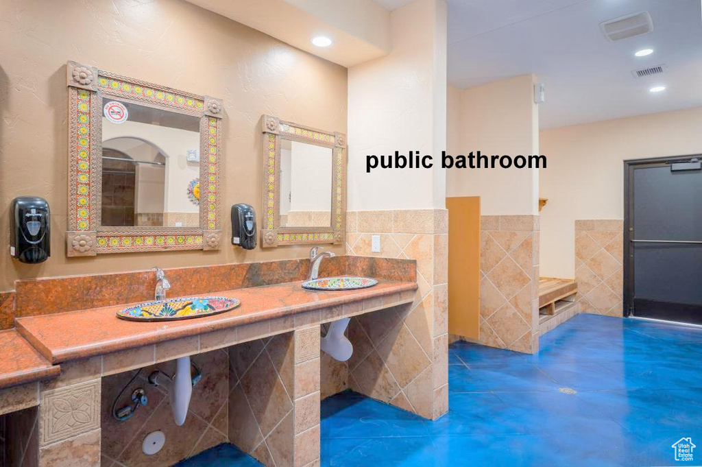 Bathroom with sink and tile walls