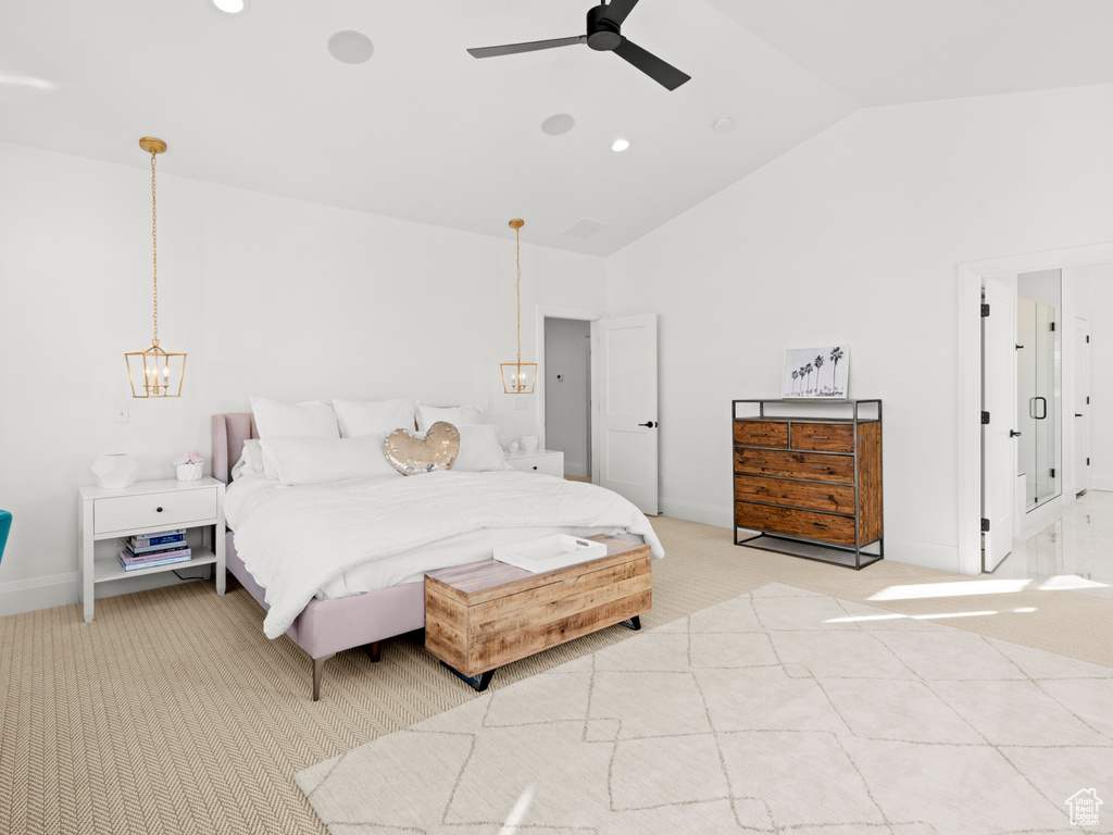 Carpeted bedroom featuring high vaulted ceiling and ceiling fan with notable chandelier
