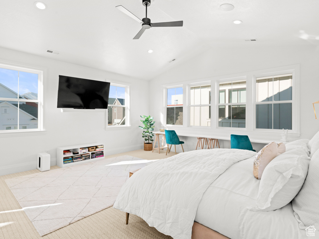 Bedroom with lofted ceiling, multiple windows, and ceiling fan