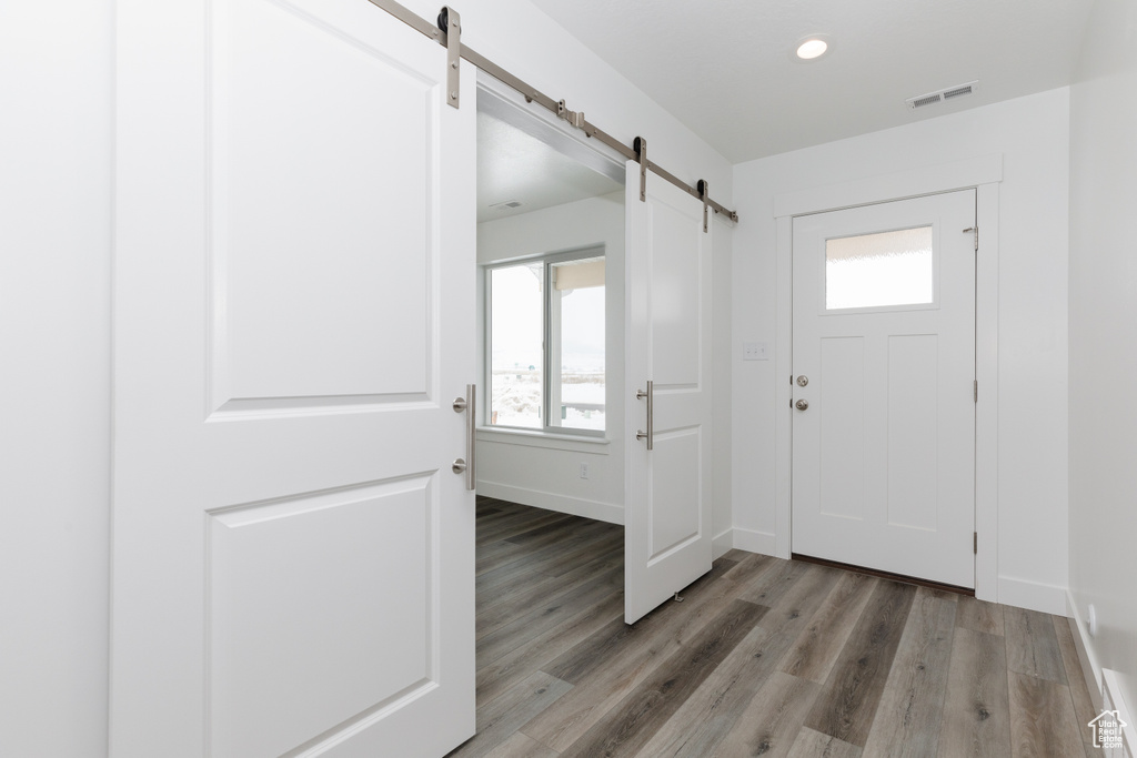 Entrance foyer with a barn door and light hardwood / wood-style floors