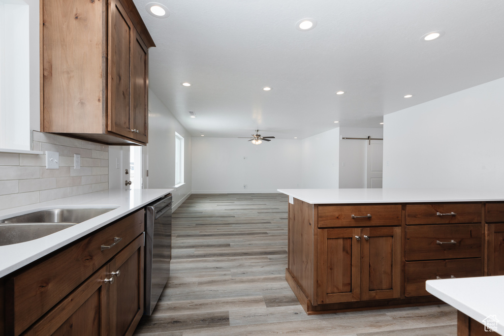 Kitchen with dishwasher, light hardwood / wood-style flooring, ceiling fan, tasteful backsplash, and dark brown cabinets
