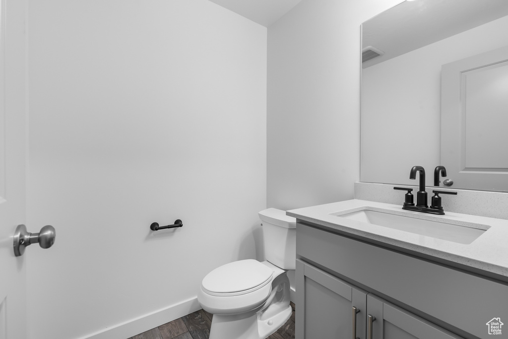 Bathroom featuring vanity with extensive cabinet space and toilet