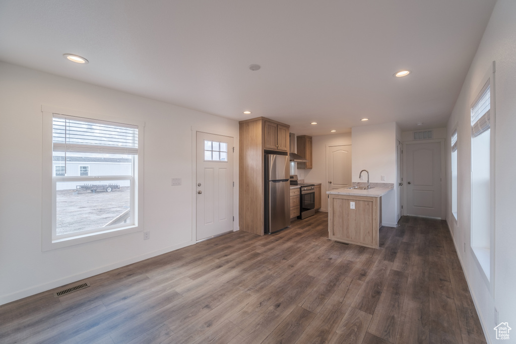Kitchen featuring dark wood-type flooring, appliances with stainless steel finishes, and plenty of natural light