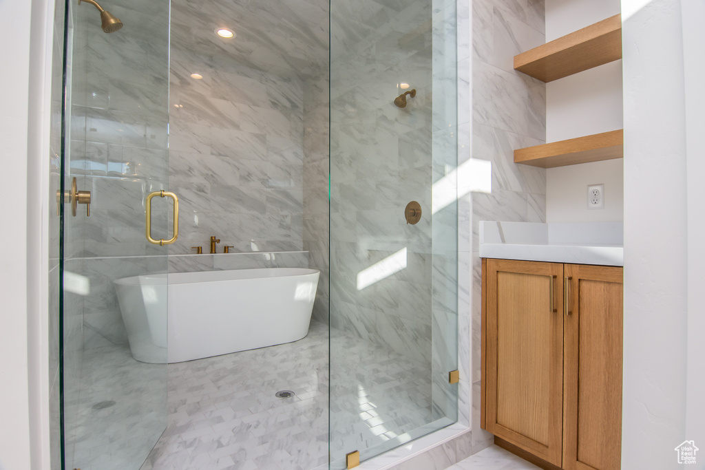 Bathroom with a shower with shower door, tile walls, and tile flooring