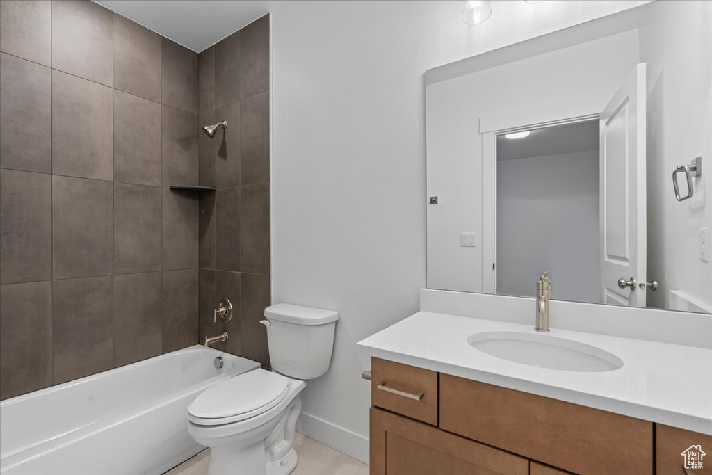 Full bathroom featuring vanity, tiled shower / bath, and toilet