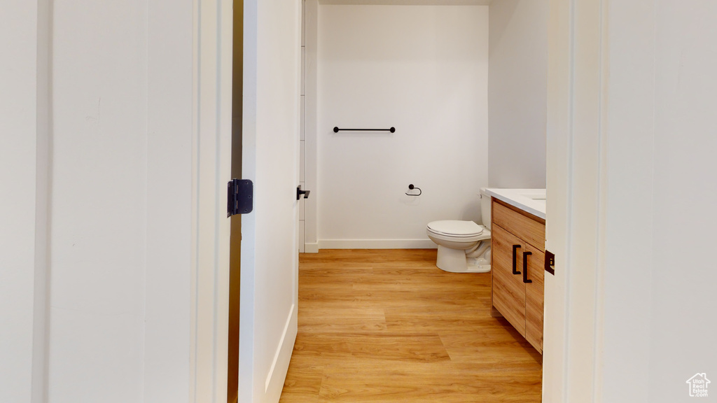 Bathroom featuring toilet, vanity, and hardwood / wood-style flooring