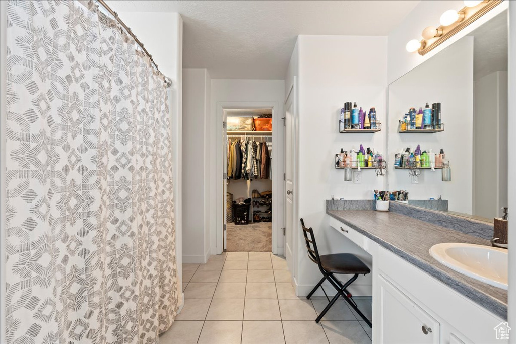Bathroom featuring tile floors and vanity with extensive cabinet space