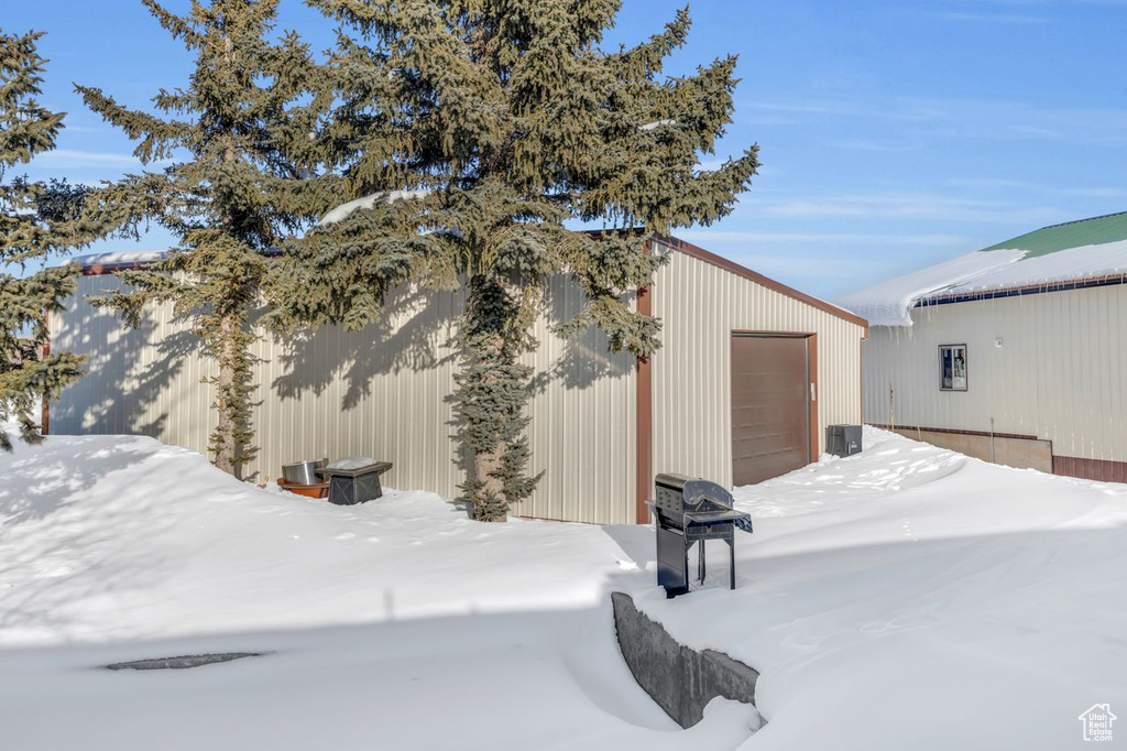 View of snow covered exterior featuring a garage