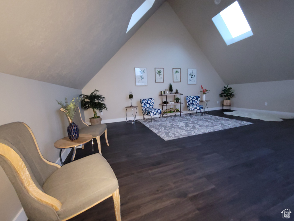 Interior space with dark hardwood / wood-style flooring and vaulted ceiling with skylight