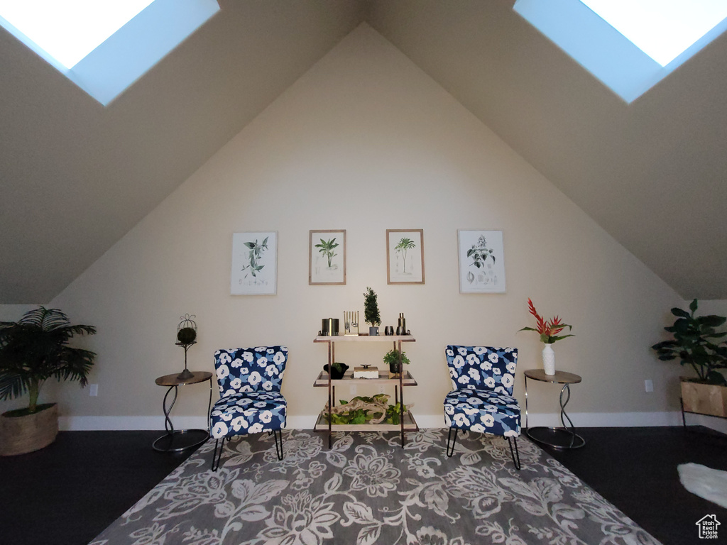 Bedroom with lofted ceiling with skylight and dark carpet