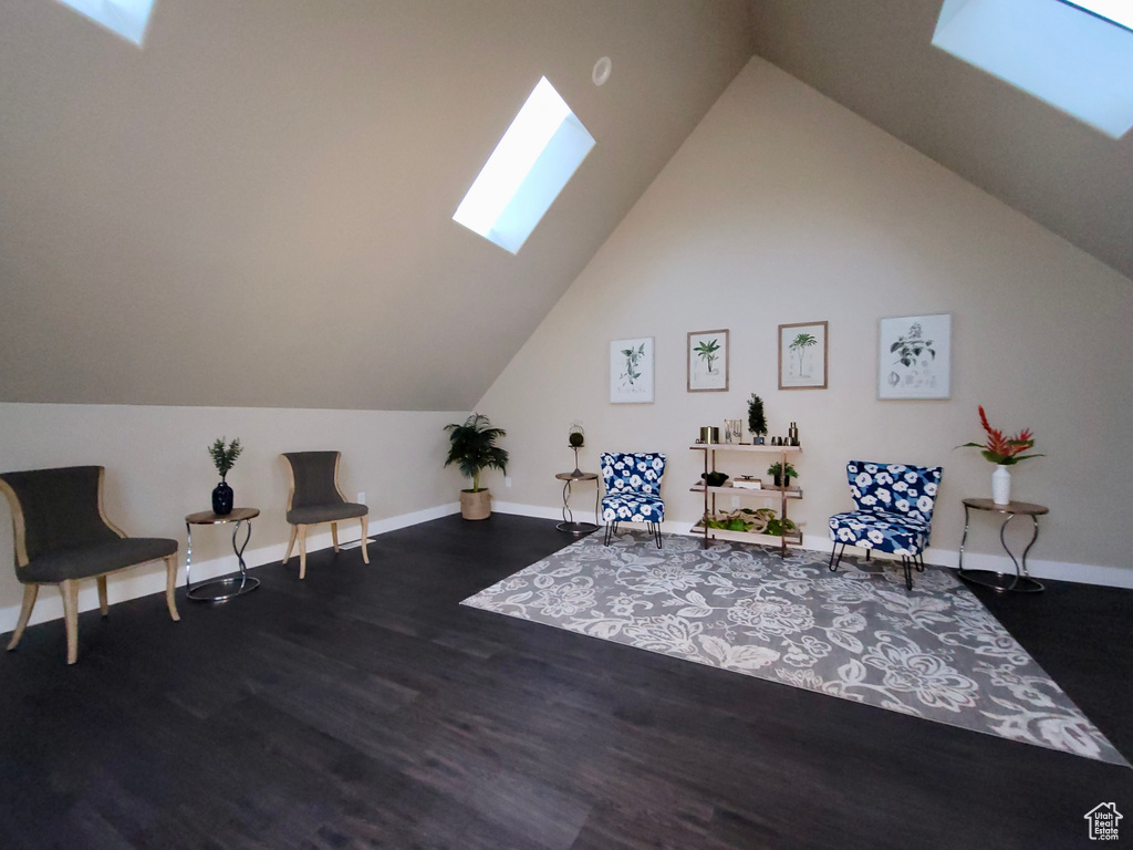 Sitting room featuring dark hardwood / wood-style flooring and lofted ceiling with skylight
