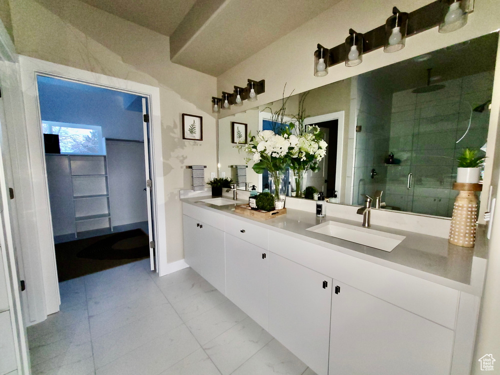 Bathroom with tile floors, a shower with door, and dual bowl vanity