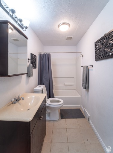 Full bathroom featuring shower / bath combination with curtain, toilet, large vanity, tile flooring, and a textured ceiling
