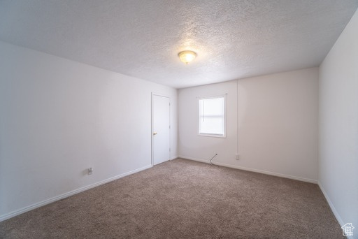 Spare room featuring carpet floors and a textured ceiling