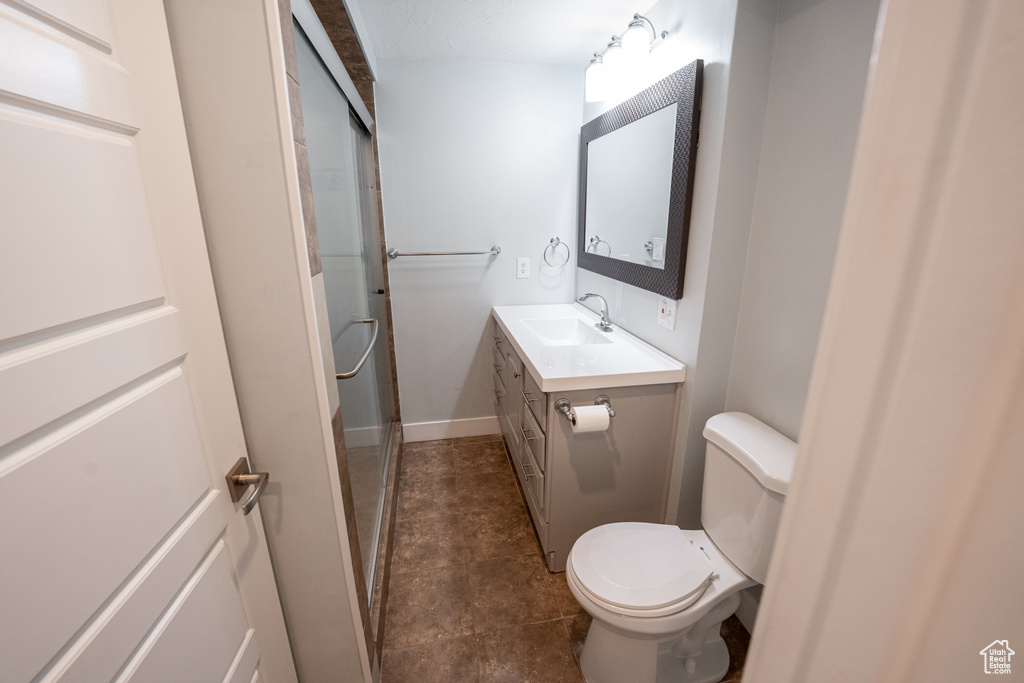 Bathroom featuring tile floors, toilet, and large vanity