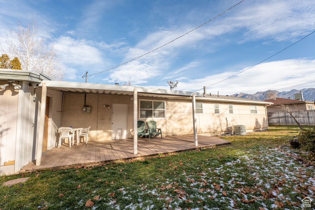 Back of property featuring central air condition unit, a lawn, and a mountain view