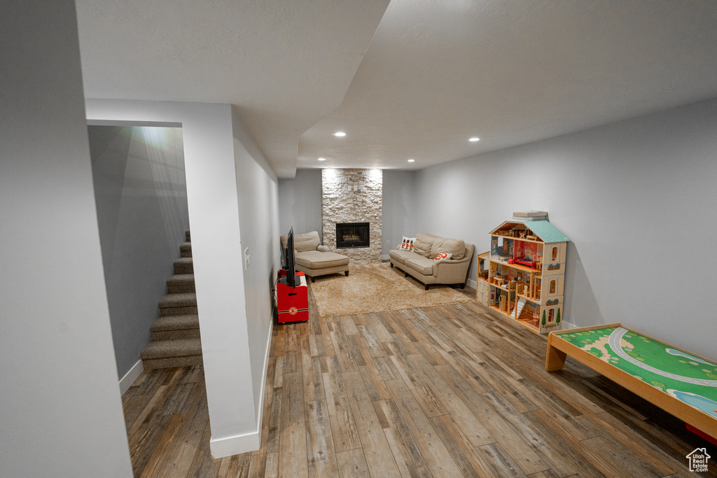 Playroom featuring a stone fireplace and hardwood / wood-style flooring