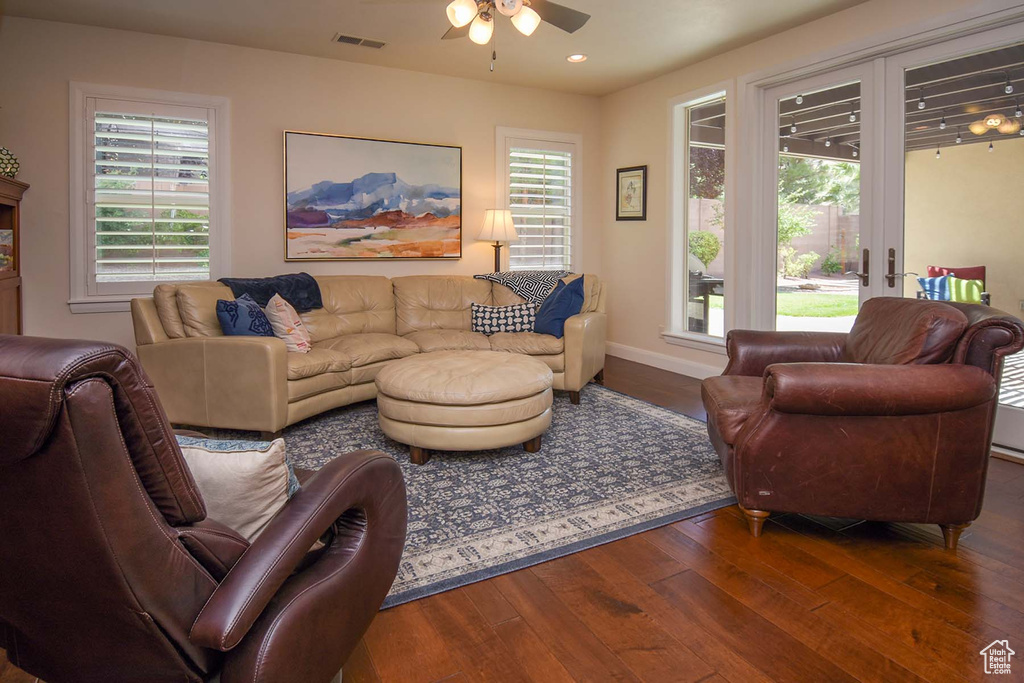 Living room featuring dark hardwood / wood-style floors, french doors, a healthy amount of sunlight, and ceiling fan