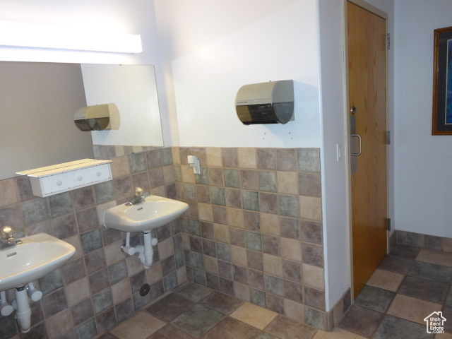 Bathroom with sink, tile walls, tasteful backsplash, and tile flooring