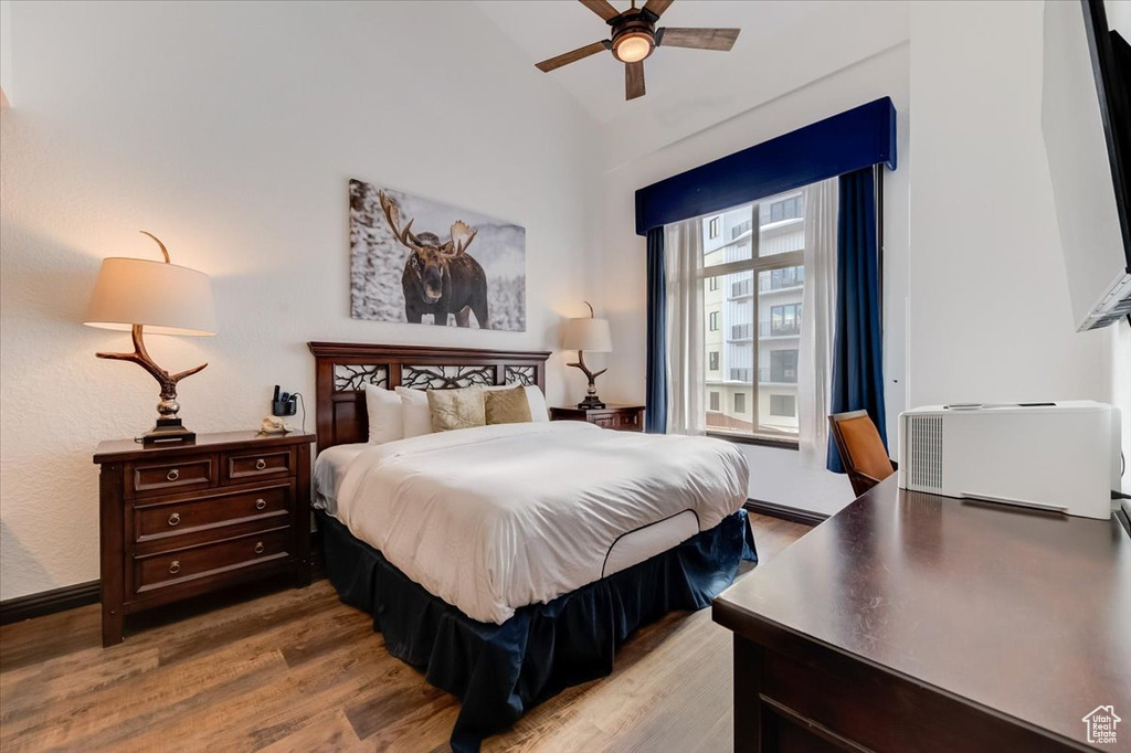 Bedroom featuring hardwood / wood-style floors, vaulted ceiling, and ceiling fan