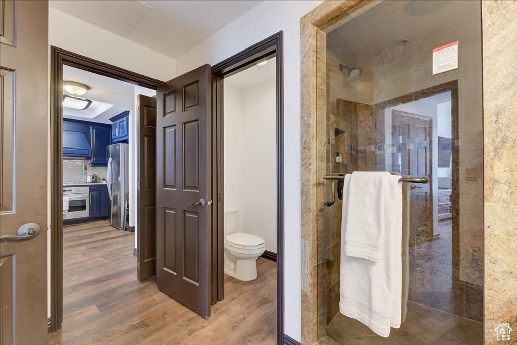Bathroom with walk in shower, toilet, and hardwood / wood-style flooring