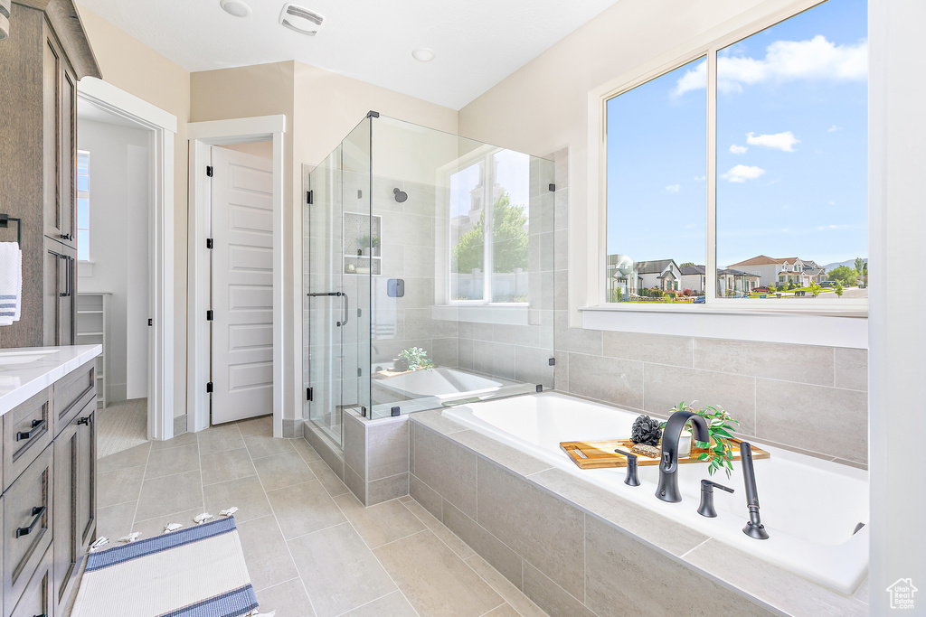 Bathroom featuring tile floors, vanity, and shower with separate bathtub