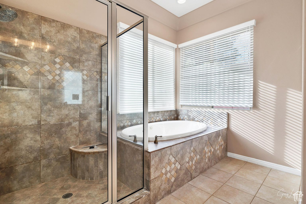 Bathroom featuring tile floors, shower with separate bathtub, and a healthy amount of sunlight