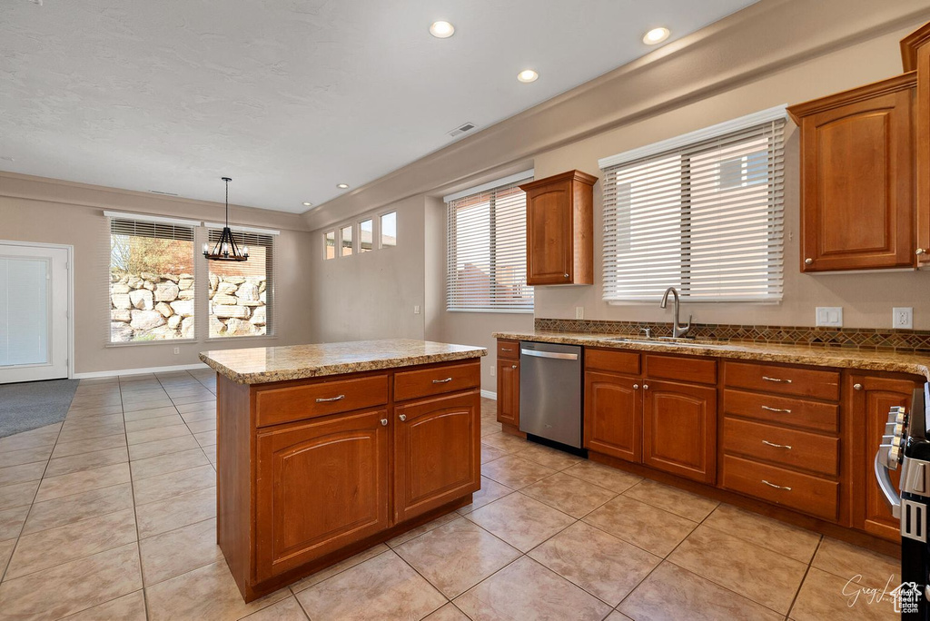 Kitchen with pendant lighting, sink, stainless steel dishwasher, and light tile flooring
