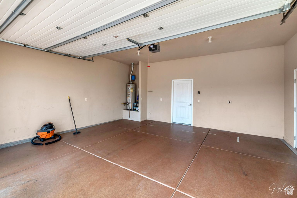 Garage featuring a garage door opener and secured water heater