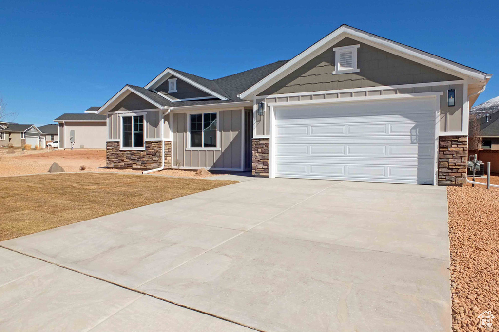 Craftsman-style house featuring a garage and a front lawn