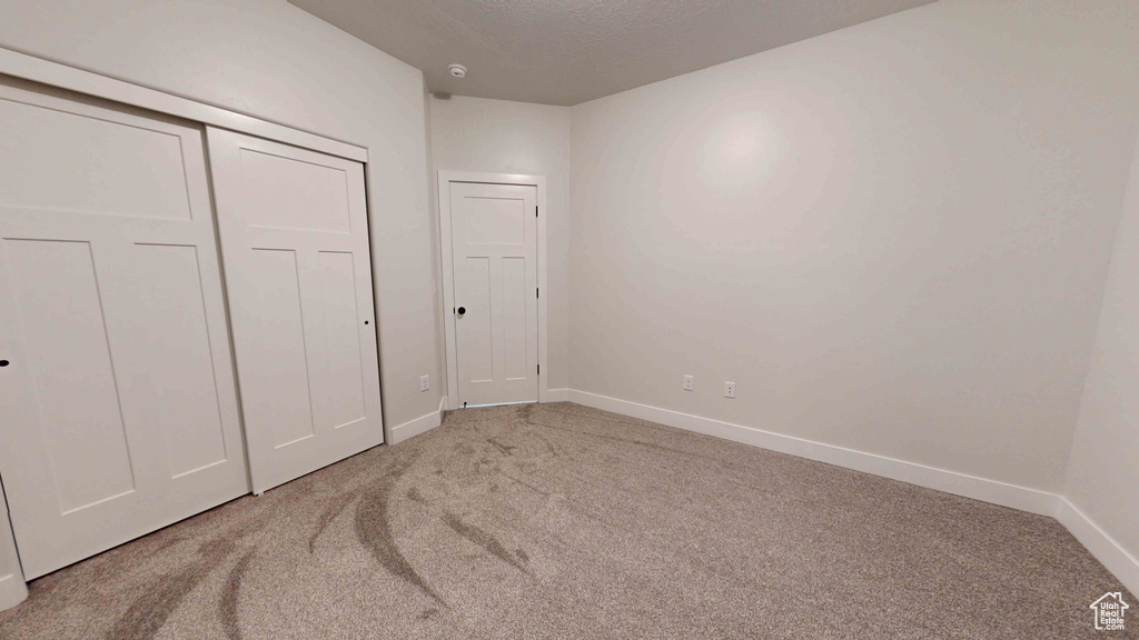 Bedroom featuring light carpet and a closet