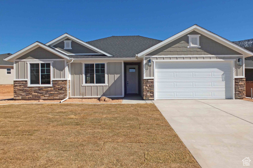 Craftsman-style house with a front lawn and a garage