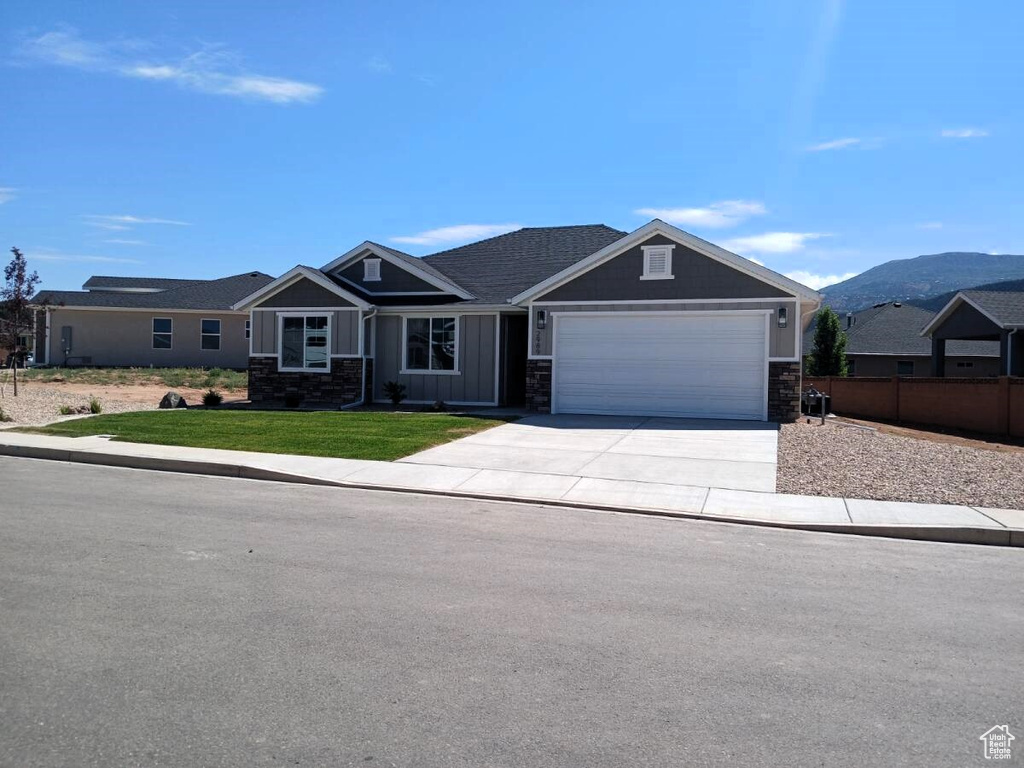 Ranch-style home with a front yard, a garage, and a mountain view