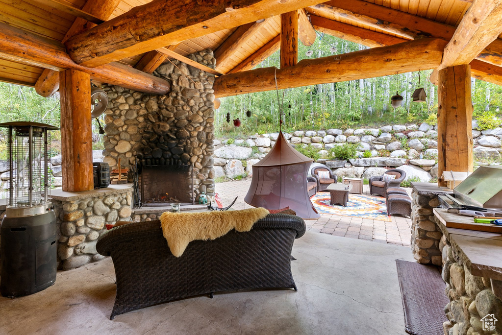View of terrace with an outdoor stone fireplace and an outdoor kitchen