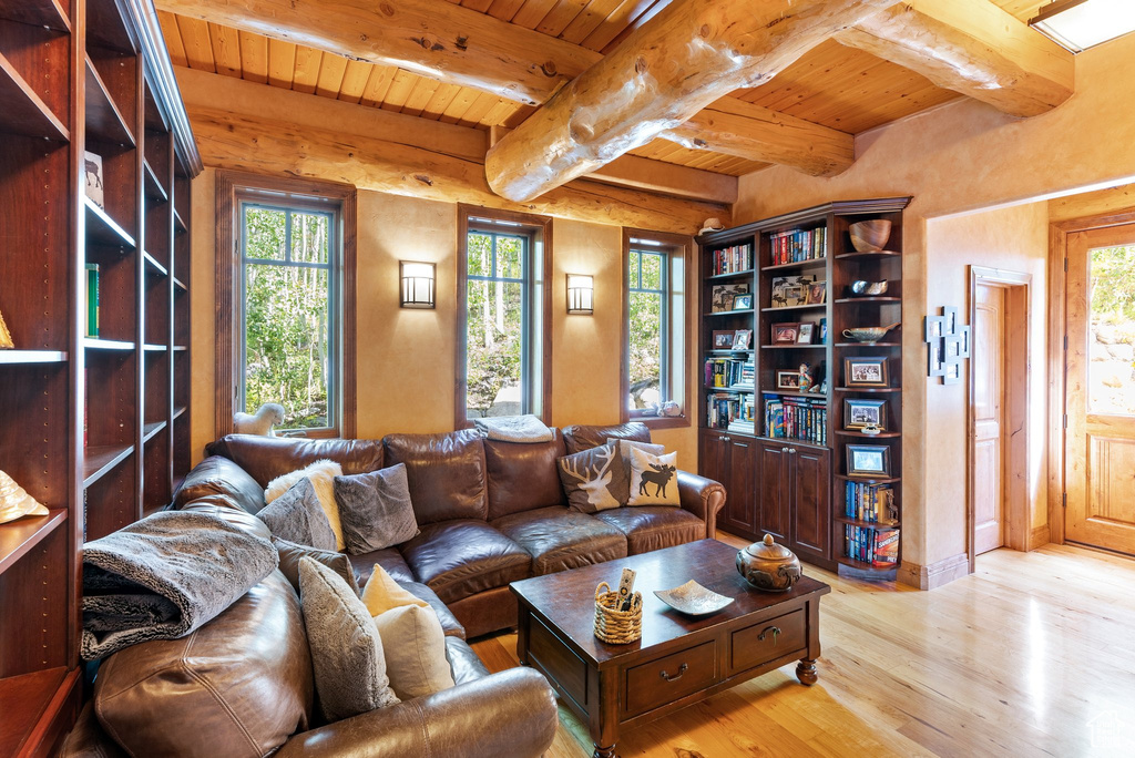 Living room with beam ceiling, light hardwood / wood-style floors, and wood ceiling