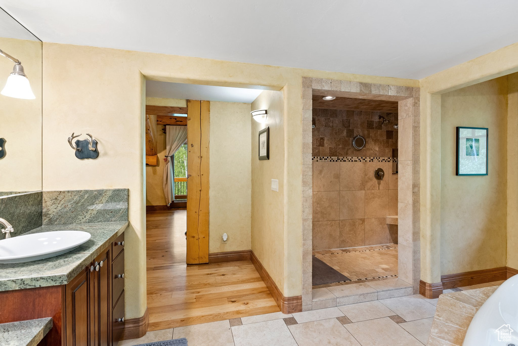 Bathroom featuring vanity, a tile shower, and hardwood / wood-style floors