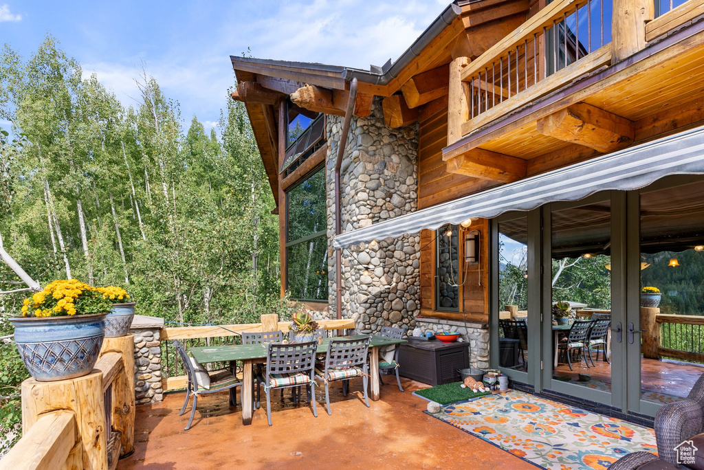 Wooden deck featuring french doors, a fireplace, and a patio