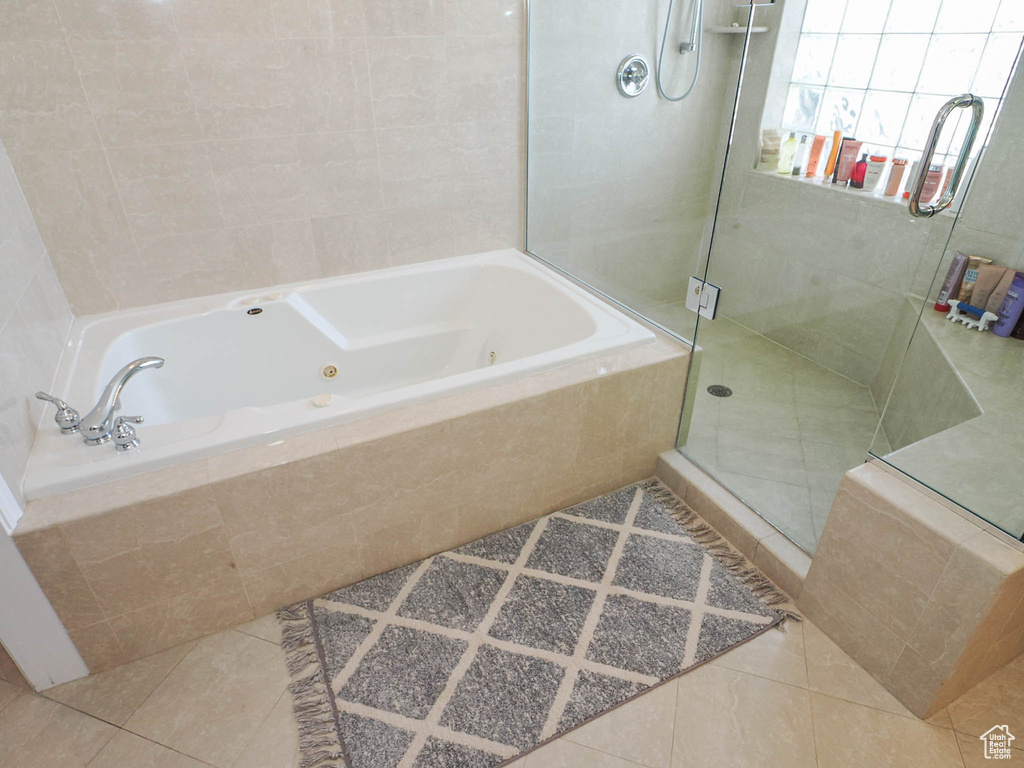 Bathroom with tile flooring and shower with separate bathtub
