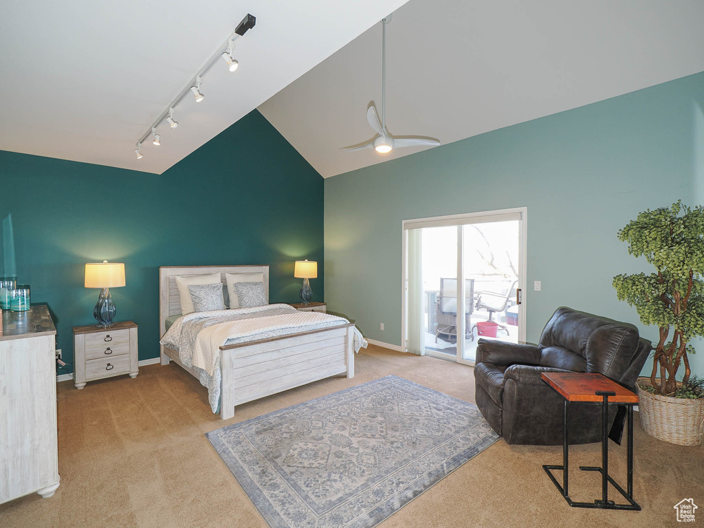 Bedroom with light carpet, rail lighting, ceiling fan, vaulted ceiling, and access to outside