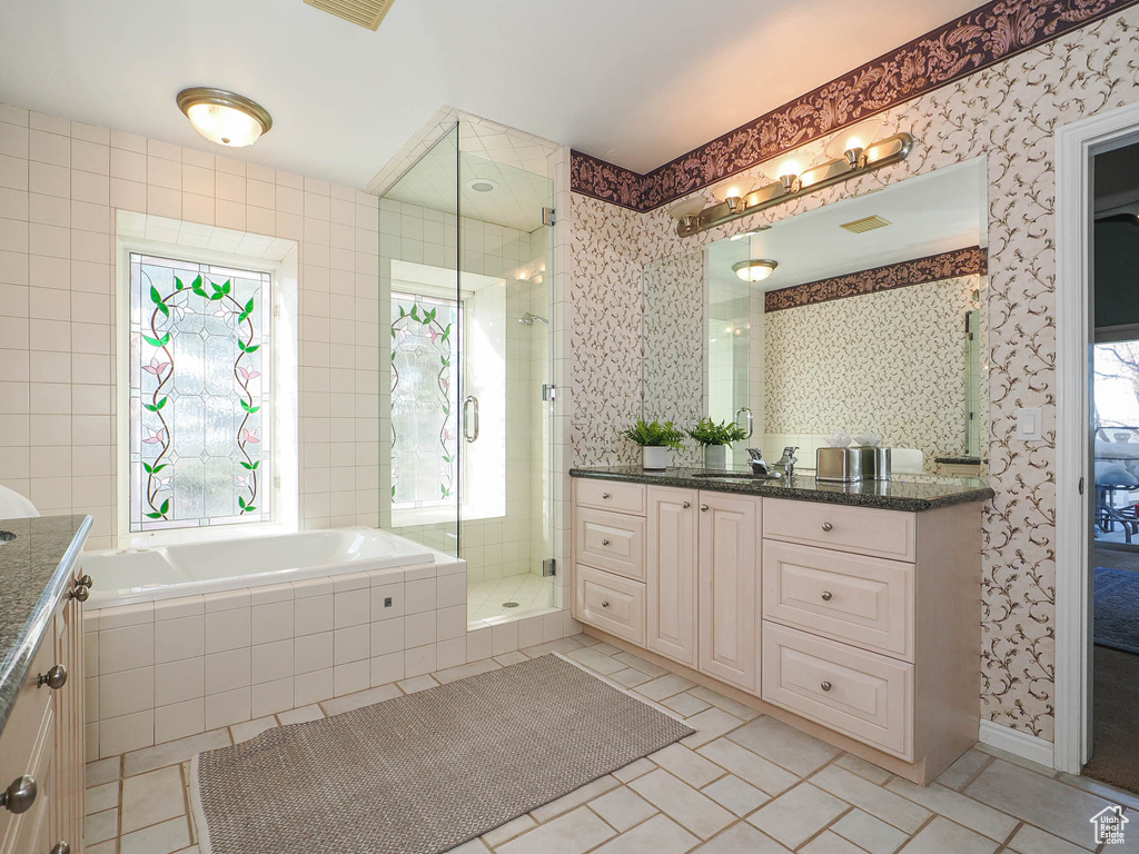 Bathroom featuring tile floors, vanity, and separate shower and tub