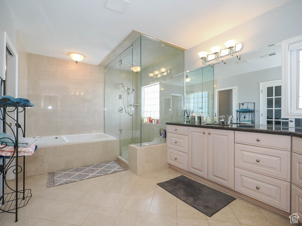 Bathroom with plus walk in shower, vanity with extensive cabinet space, and tile flooring