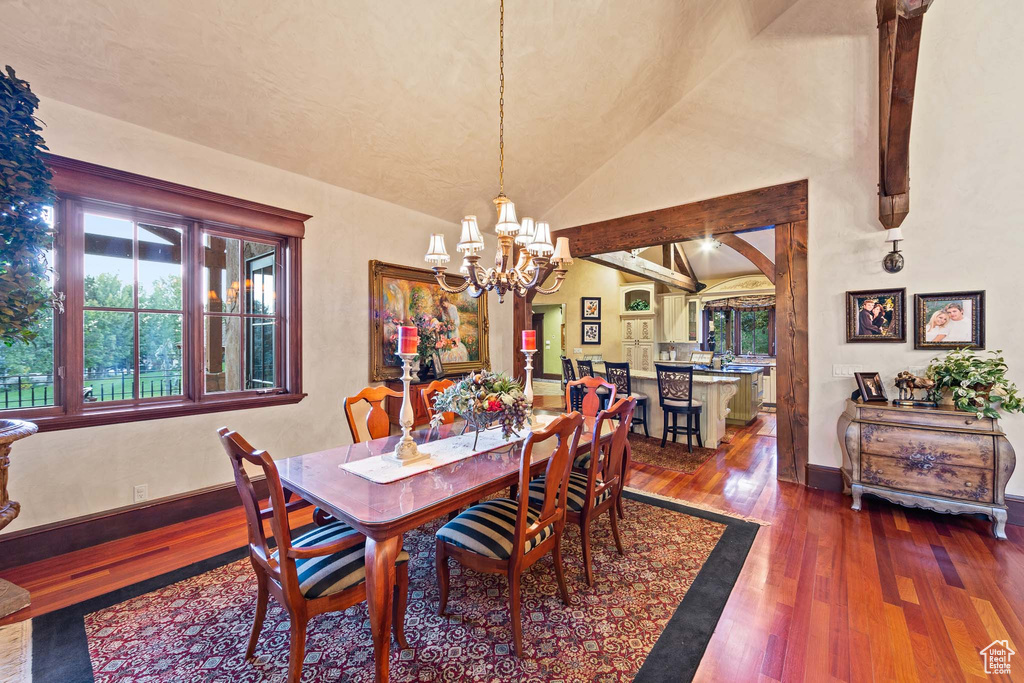 Dining room featuring high vaulted ceiling, a notable chandelier, and dark hardwood / wood-style floors