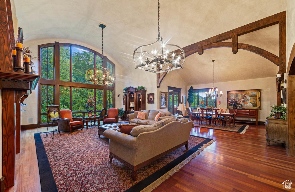 Living room with a chandelier, dark hardwood / wood-style floors, and high vaulted ceiling