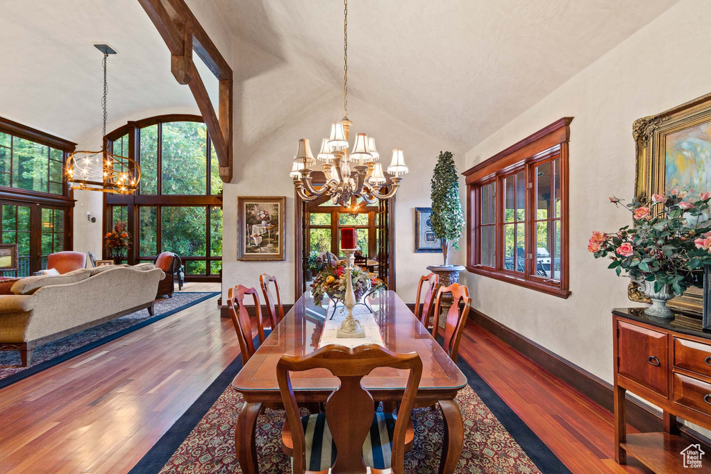 Dining space featuring a chandelier, dark hardwood / wood-style flooring, and high vaulted ceiling