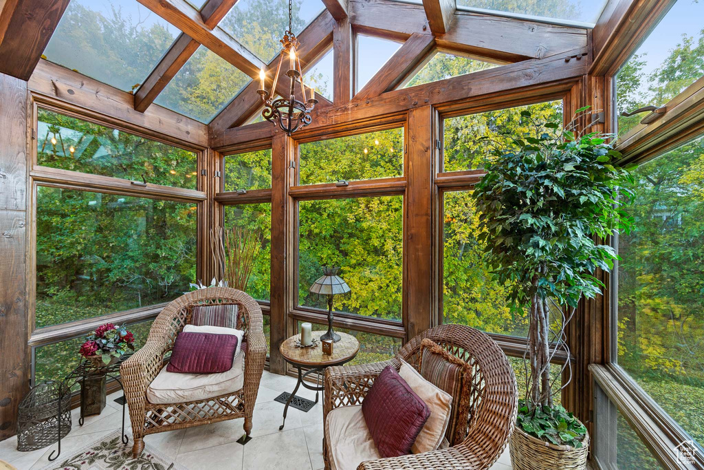 Sunroom featuring a chandelier and vaulted ceiling with beams